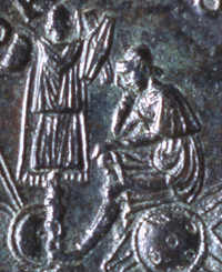 Figura 4 – Traiano (98-117 d.C.). Sesterzio emesso dalla zecca di Roma tra il 106 e il 111 con la Dacia seduta su scudi accanto a trofeo (particolare del rovescio). Roma, Museo Nazionale Romano, Medagliere